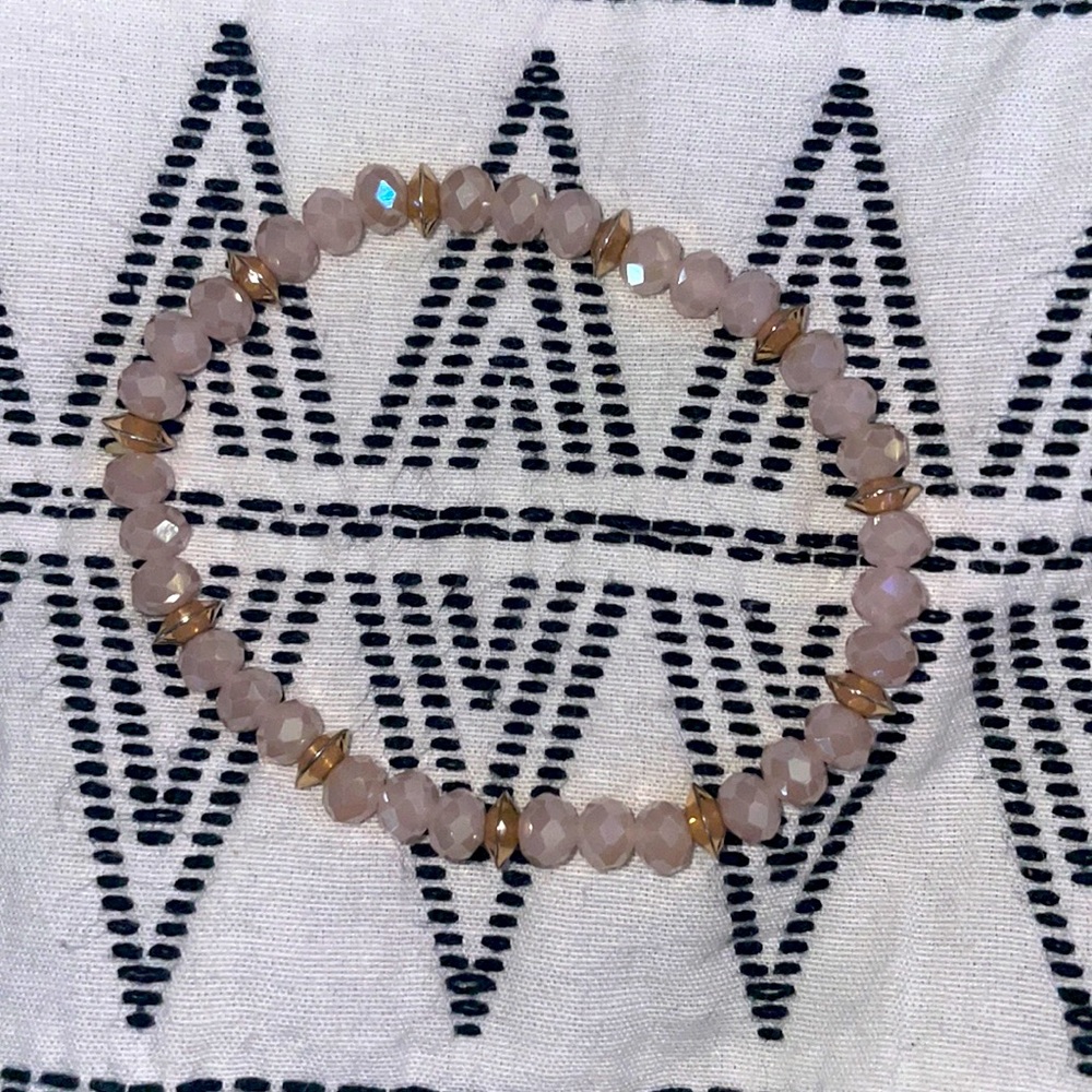 This is a bracelet with pink and gold beads!